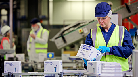 Siobhan Taub looking at a box of Sensodyne toothpaste on a production line, Maidenhead UK