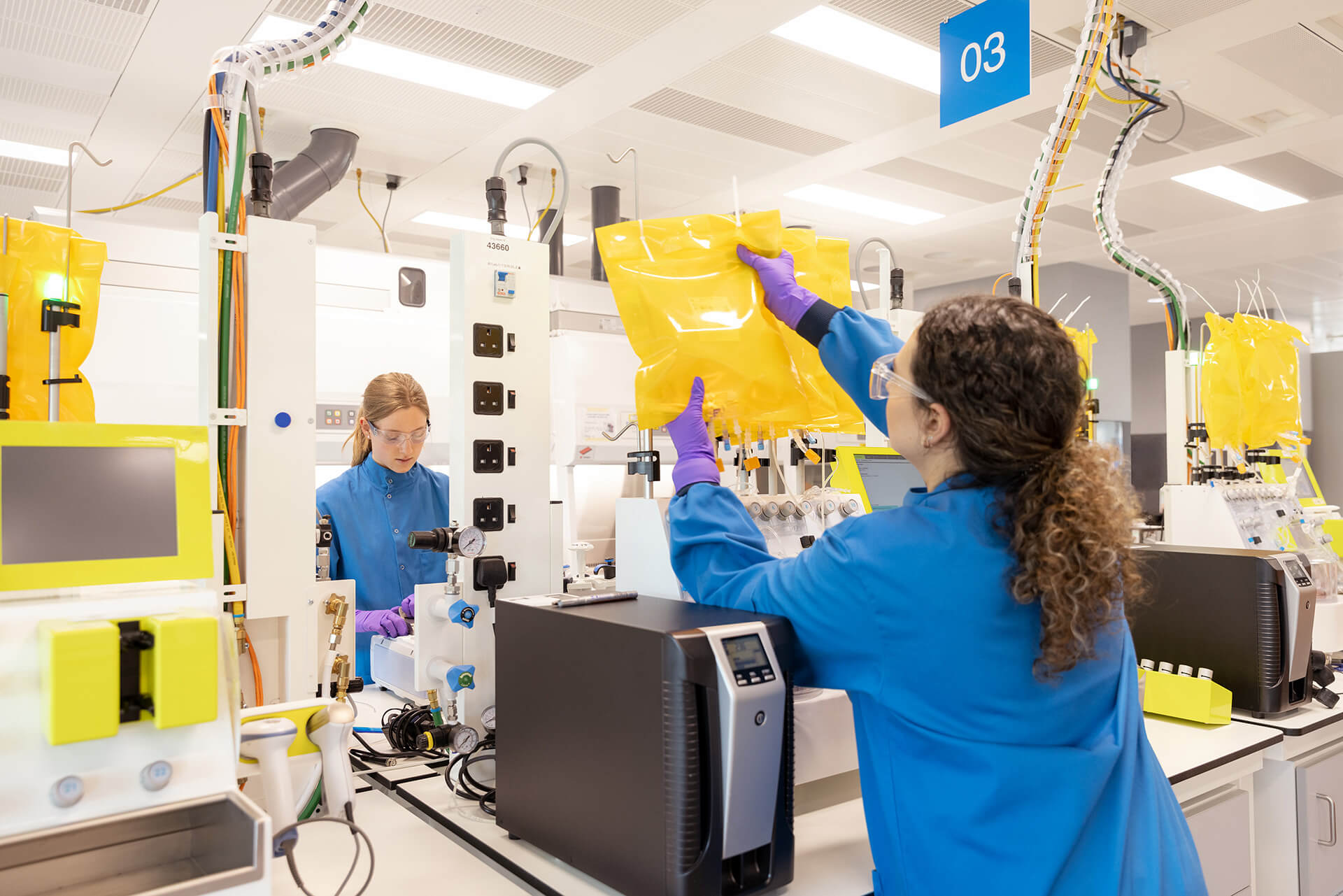 Woman adjusting a machine in a lab