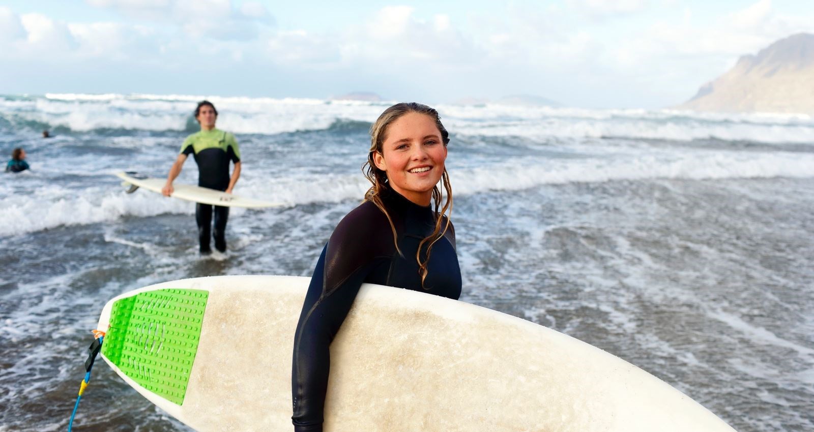 Woman standing with a surfboard at the ocean