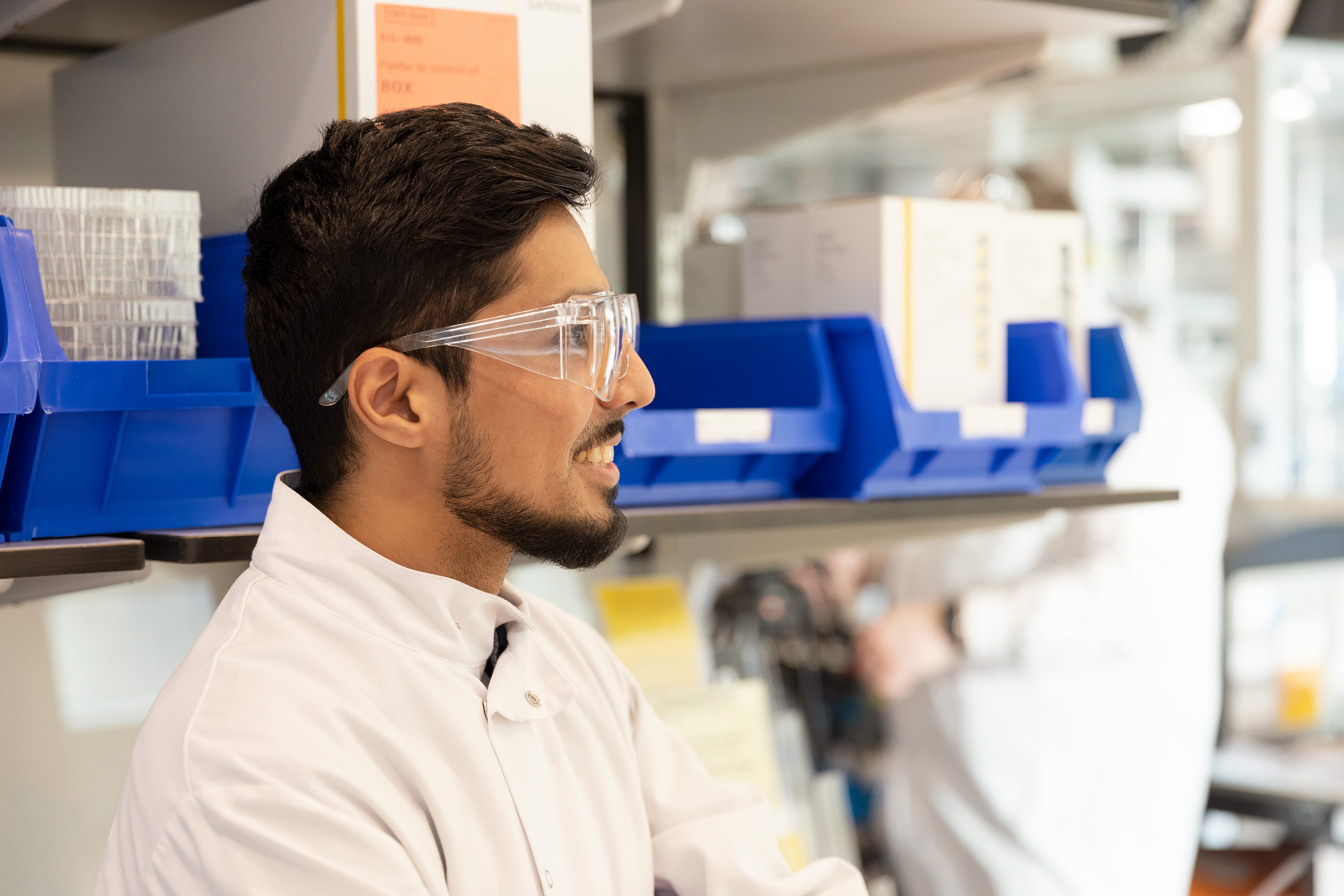 Homme en blouse de laboratoire qui ne regarde pas en direction de la caméra