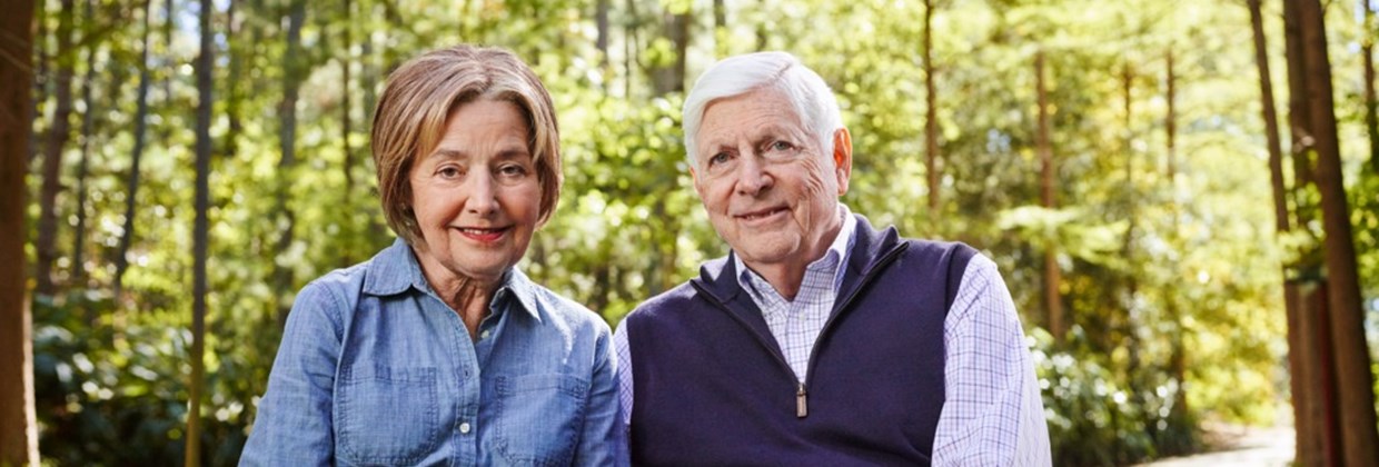 Elderly couple sitting together in a forest