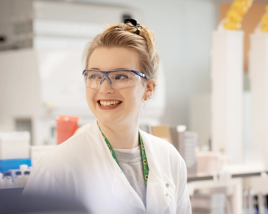 Femme qui sourit, vêtue d’un sarrau