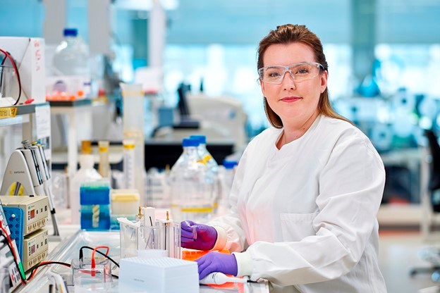 Woman working in a lab while looking at the camera