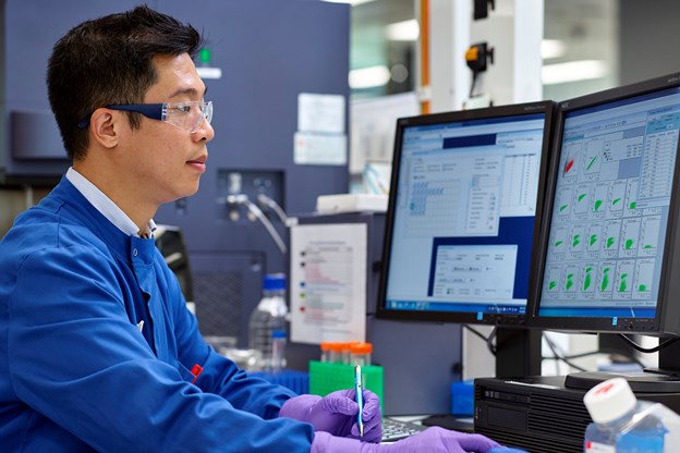 Man in lab looking at computer screens