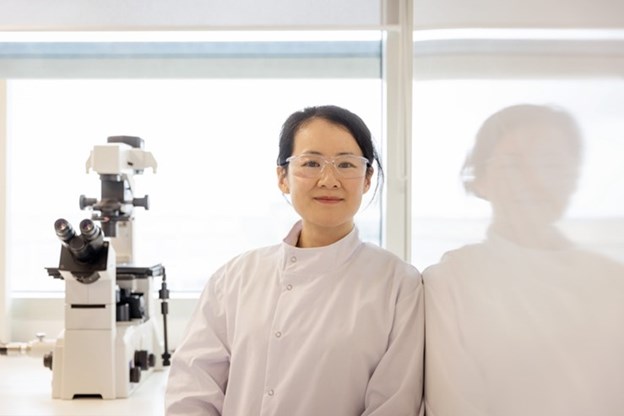 Woman in a lab smiling at the camera