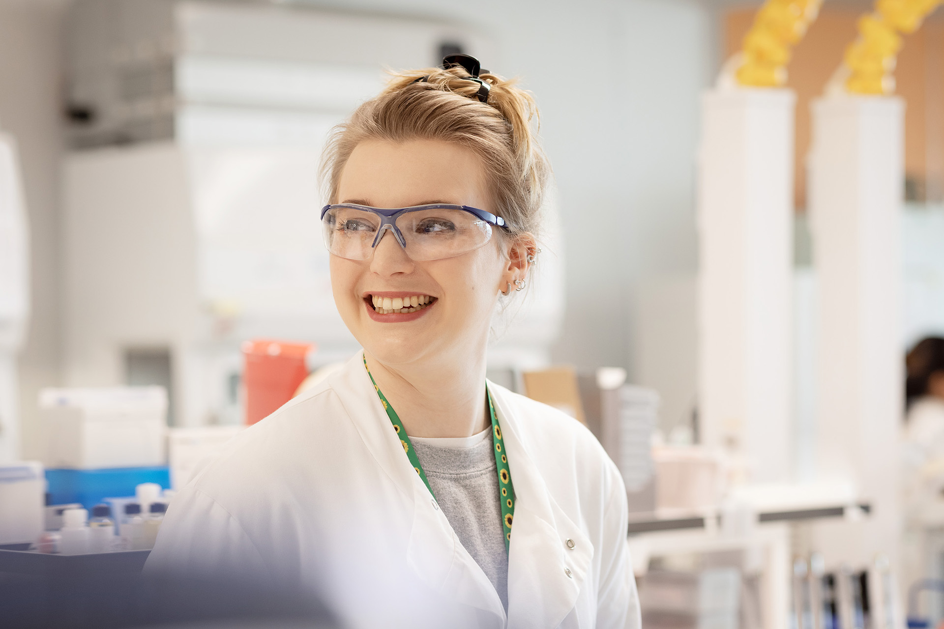 Woman smiling while in a lab coat