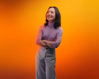 Femme souriant sur fond orange
