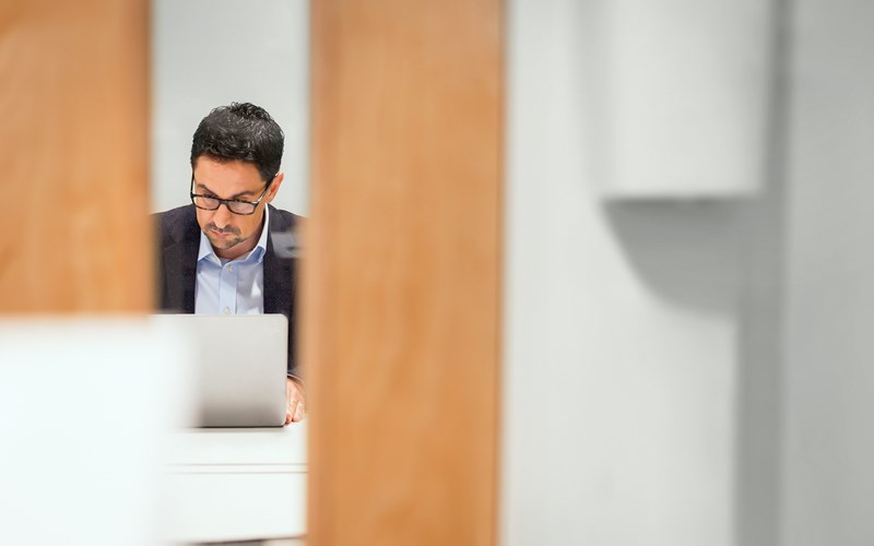 Photo prise sur le vif d’une personne travaillant sur un ordinateur portable dans un bureau.