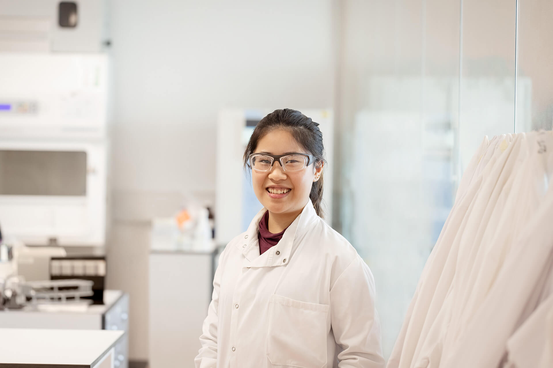 Woman in a labcoat smiling at the camera