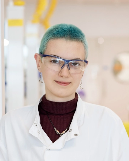 Femme aux cheveux bleus qui sourit à la caméra