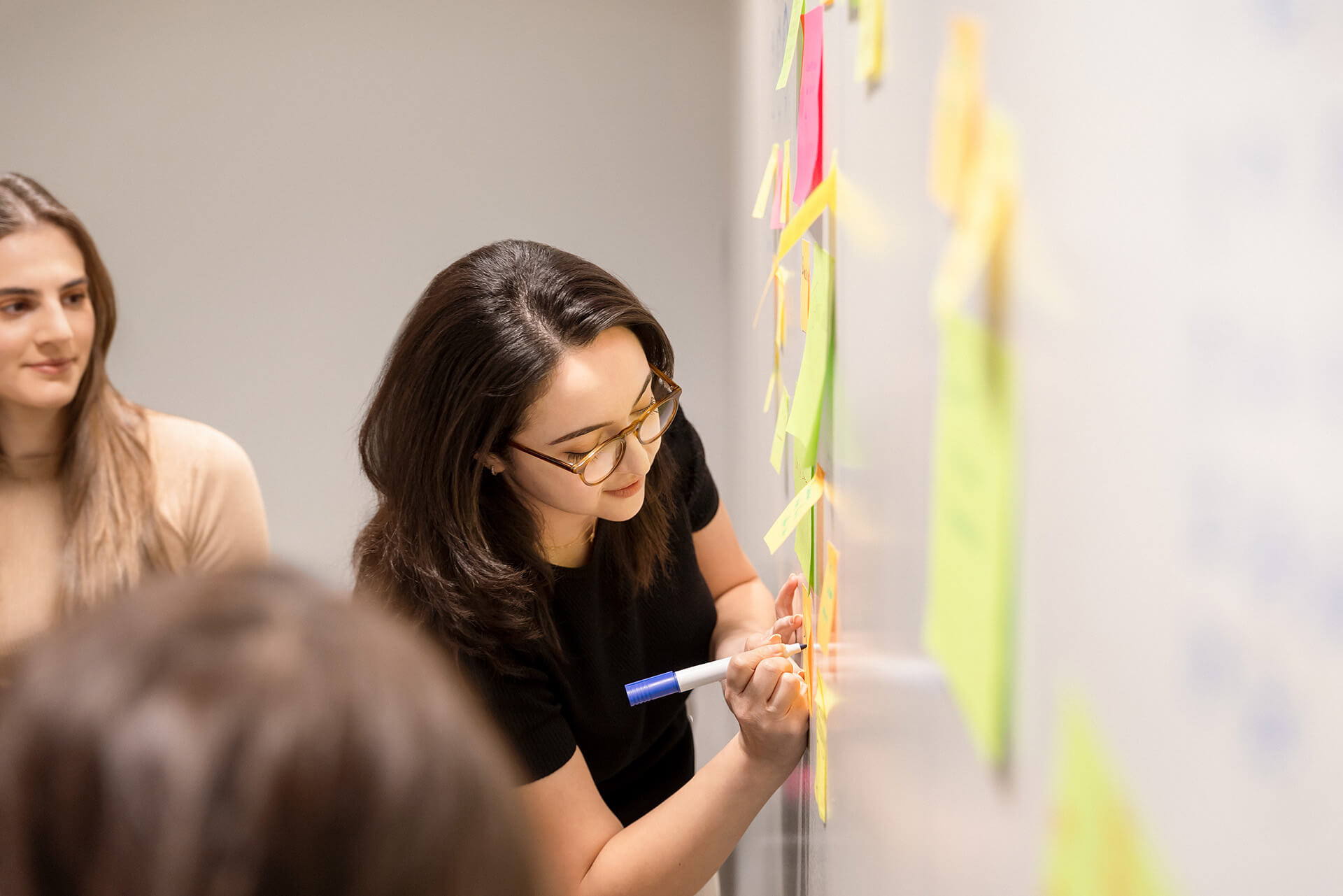 Woman working on a whiteboard.