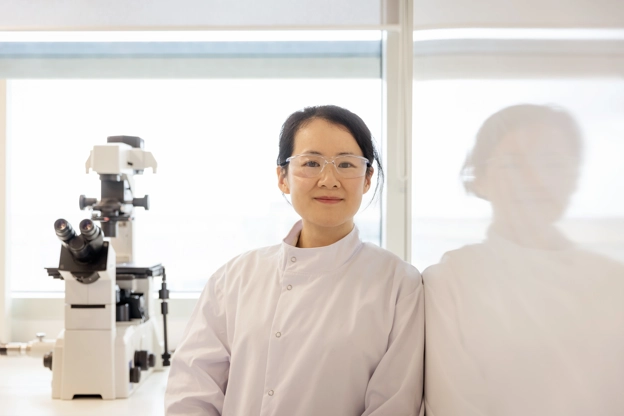 Femme dans un laboratoire qui sourit à la caméra