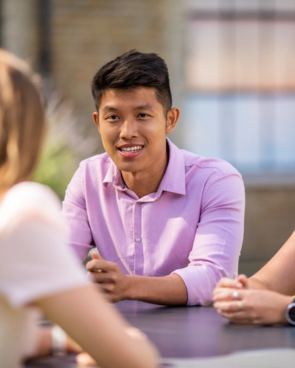 Group of people sitting together around a table