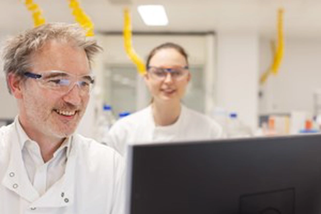 Un homme et une femme dans un laboratoire regardent un écran d’ordinateur