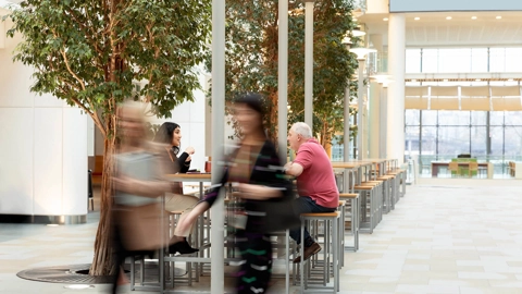Two blurred figure in a large room.