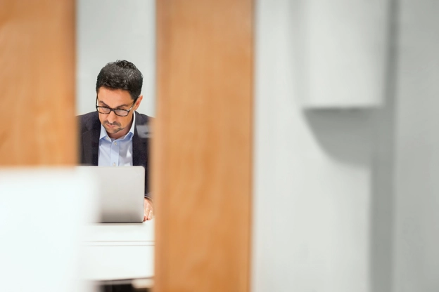 Photo prise sur le vif d’une personne travaillant sur un ordinateur portable dans un bureau.
