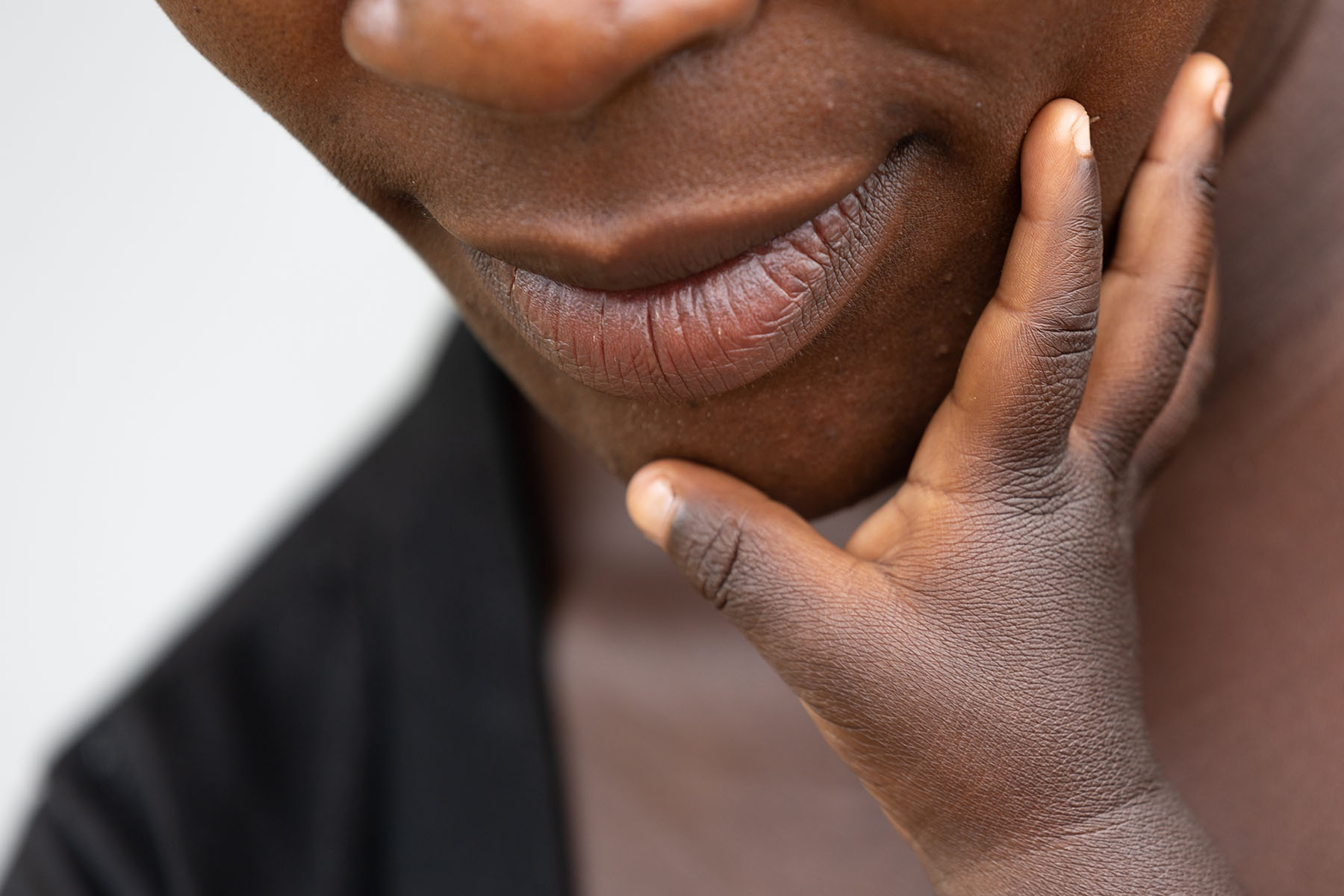 Hand reaching up to a person's face