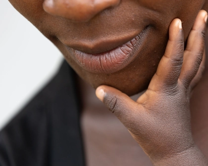 Hand reaching up to a person's face