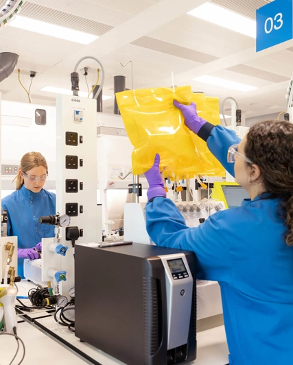 Woman adjusting a machine in a lab