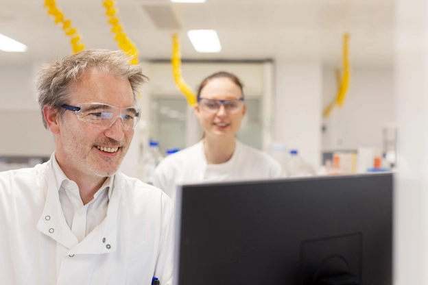 Man and woman in lab looking at a computer monitor