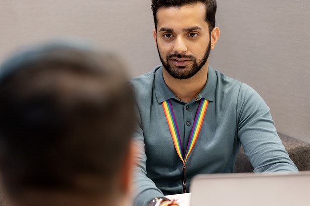 Man with a rainbow lanyard in an office