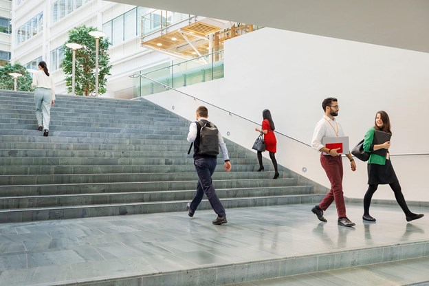 Groupe de personnes qui marchent en conversant dans un bureau