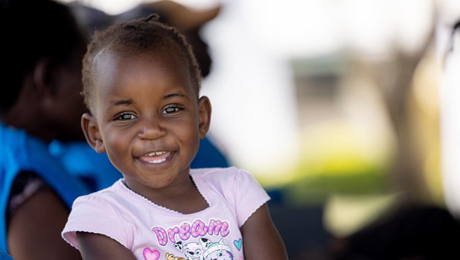 Petite fille dans un t-shirt rose souriant