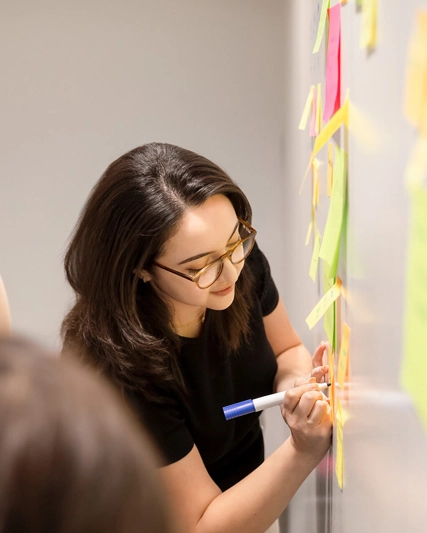 Woman working on a whiteboard.