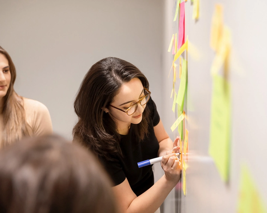 Woman working on a whiteboard.