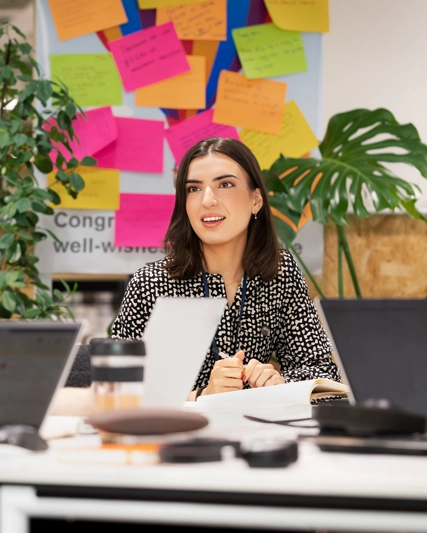 Two women speaking together over a desk in an office.