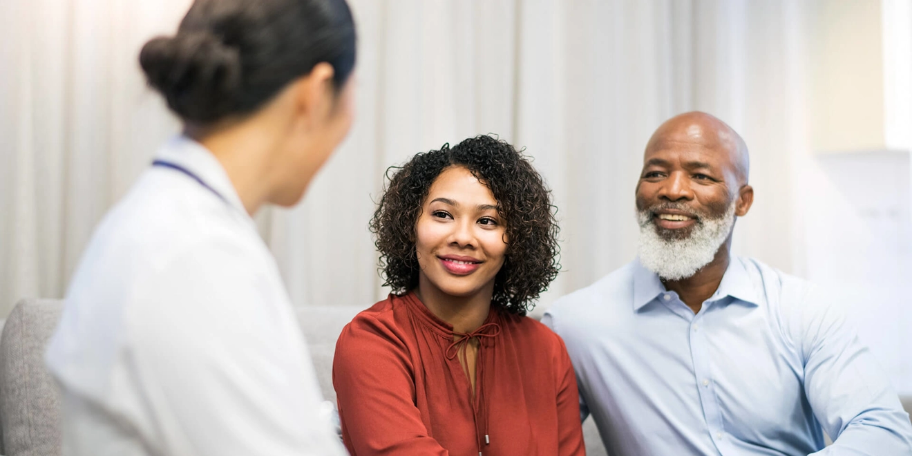 Two people listening to a doctor