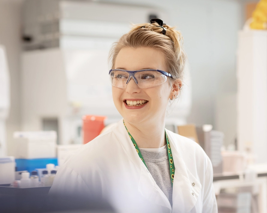 Woman smiling while in a lab coat